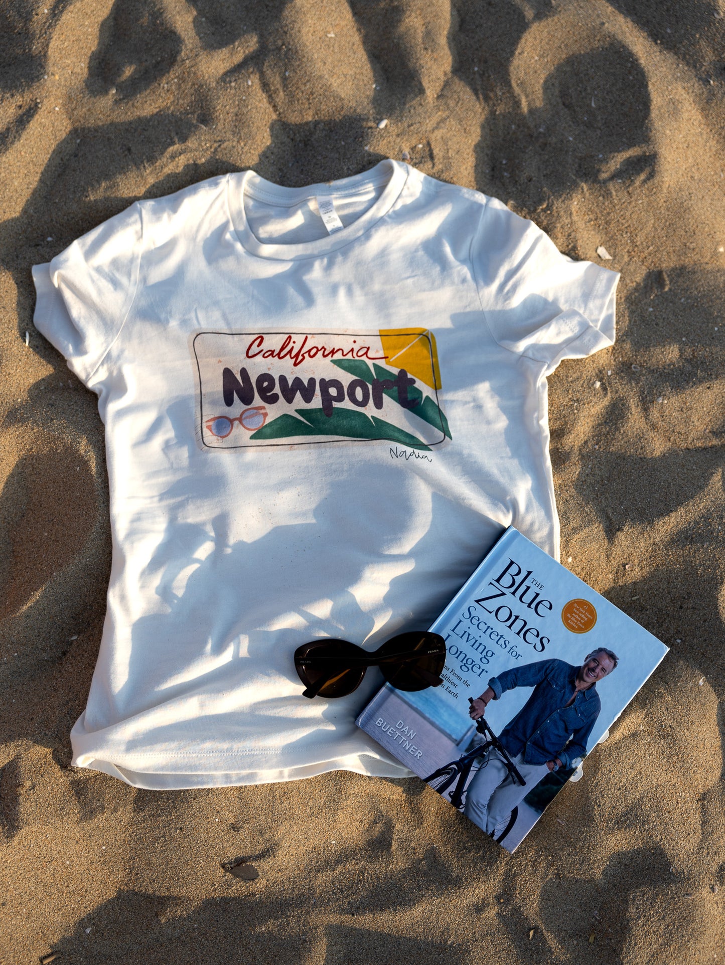 Handmade t-shirt featuring artist-designed Newport, CA license plate illustration.