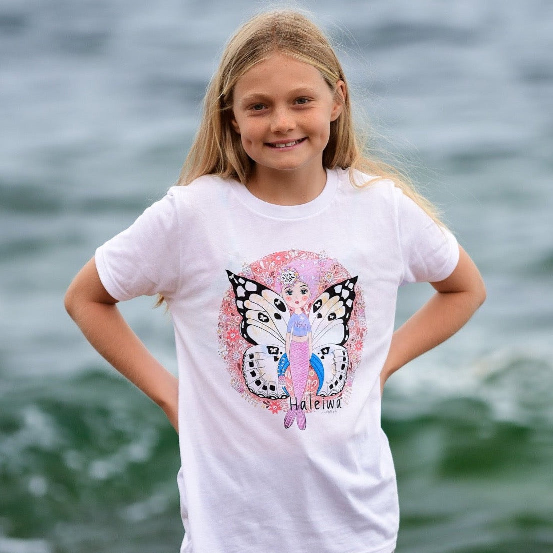 Girl's graphic tee featuring mermaid with butterfly wings, surrounded by colorful Hawaiian florals.