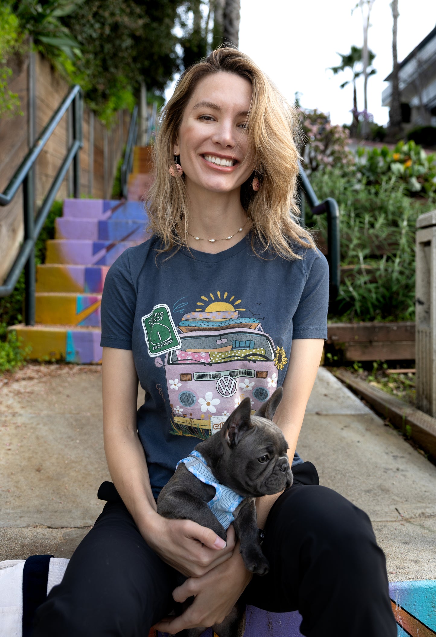 Woman in a blue North Shore Girls graphic t-shirt features a hand-drawn vintage floral beach van.
