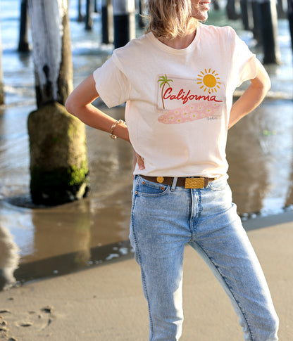 California graphic tee, relaxed fit, featuring pink floral surfboard, palm tree & sun.