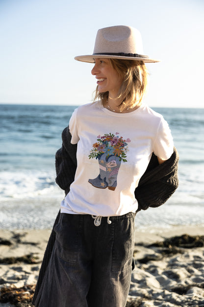 Women's white graphic t-shirt featuring a hand-drawn cowboy boot with a mermaid and flowers, North Shore Girls brand.