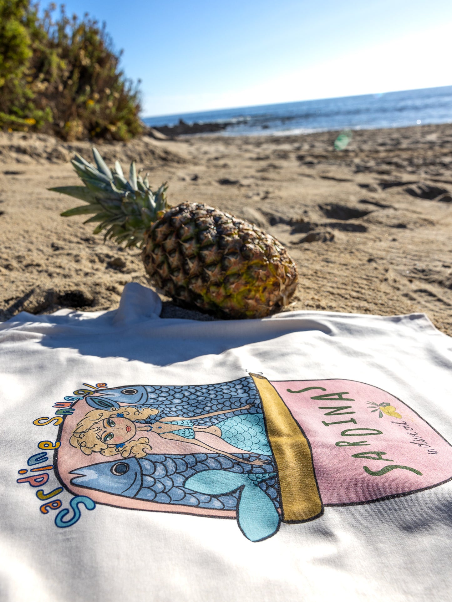 Unique mermaid graphic tee with hand-illustrated sardine can design.