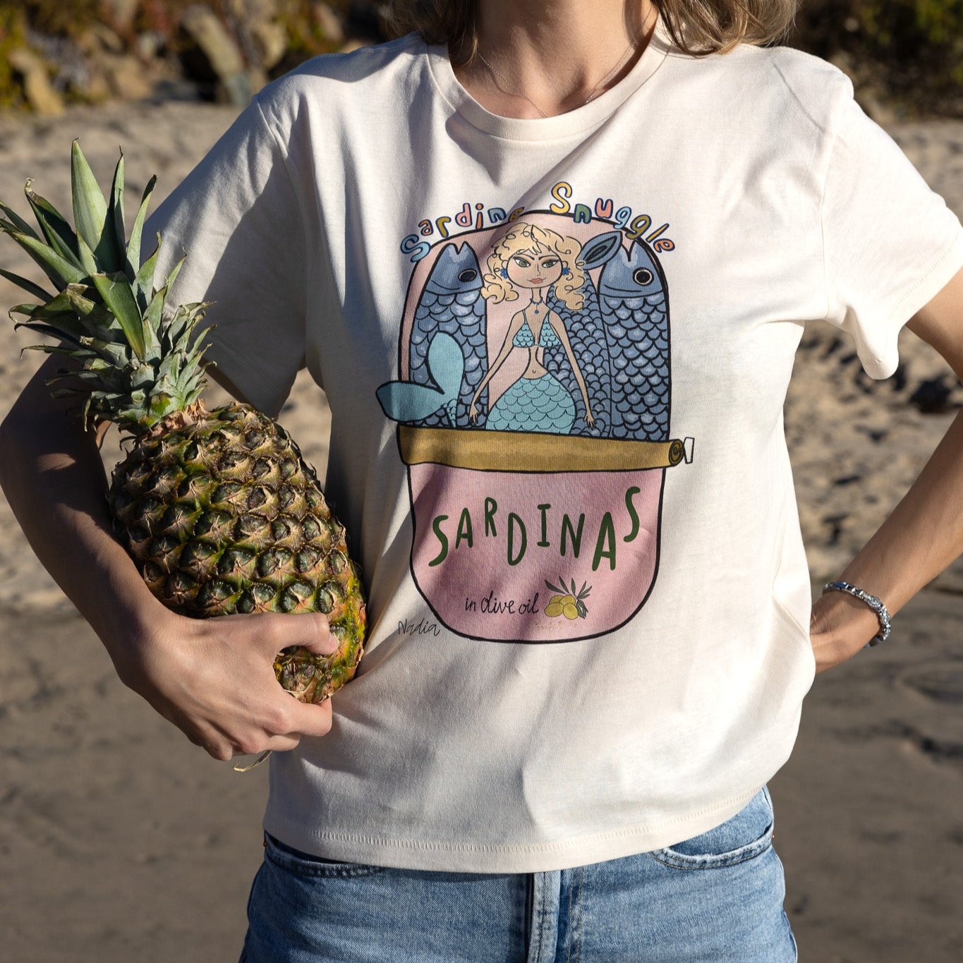 Playful mermaid graphic tee with sardine can design, hand-illustrated by local SoCal artist