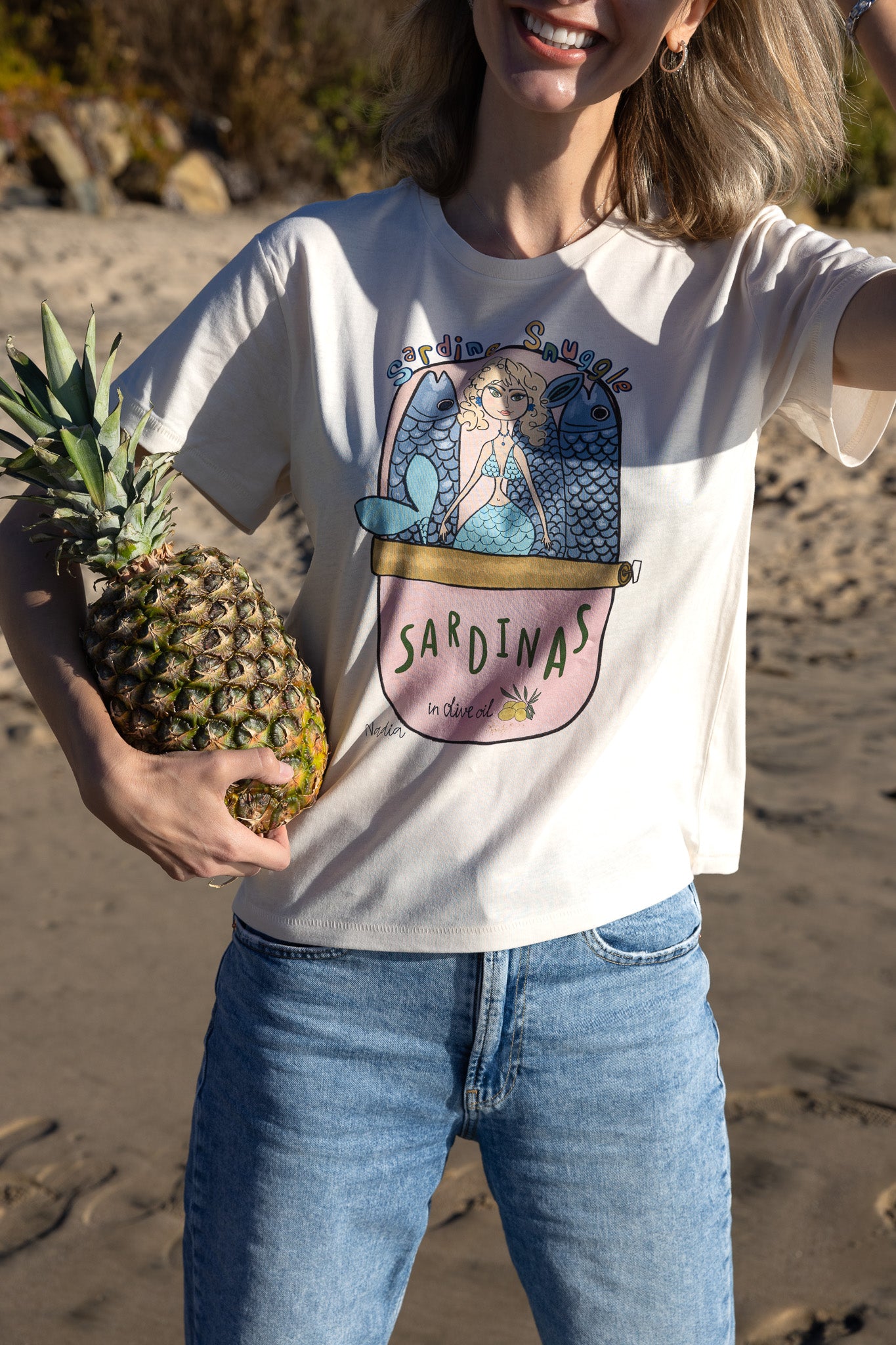 Playful mermaid graphic tee with sardine can design, hand-illustrated by local SoCal artist.