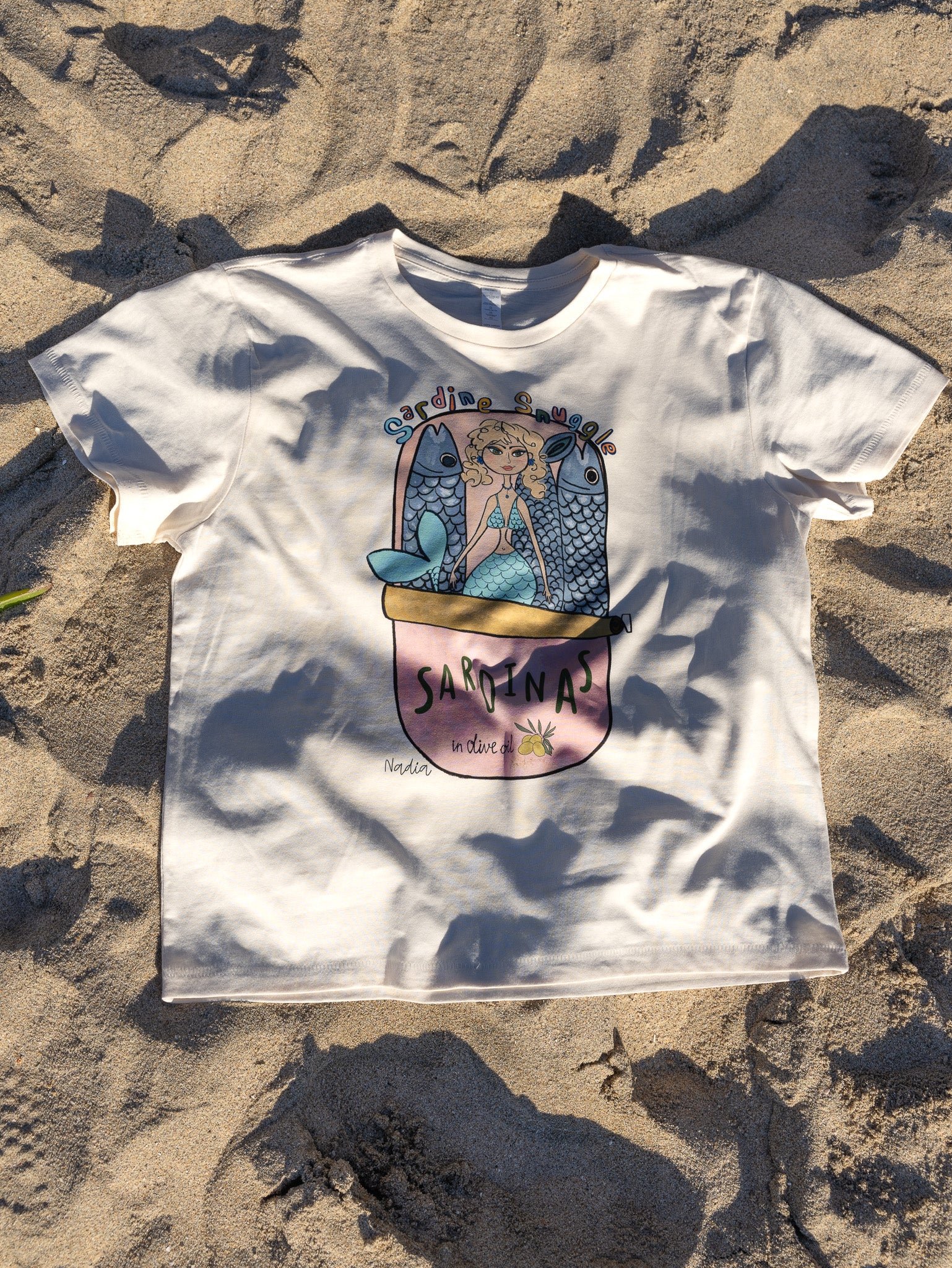 Playful mermaid graphic tee with sardine can design, hand-illustrated by local SoCal artist.