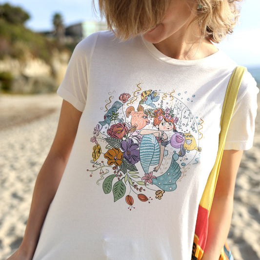 Graphic tee for women featuring an illustration of read headed mermaid surrounded by her fish friends and flowers. Designed and printed in Southern California by a local artist