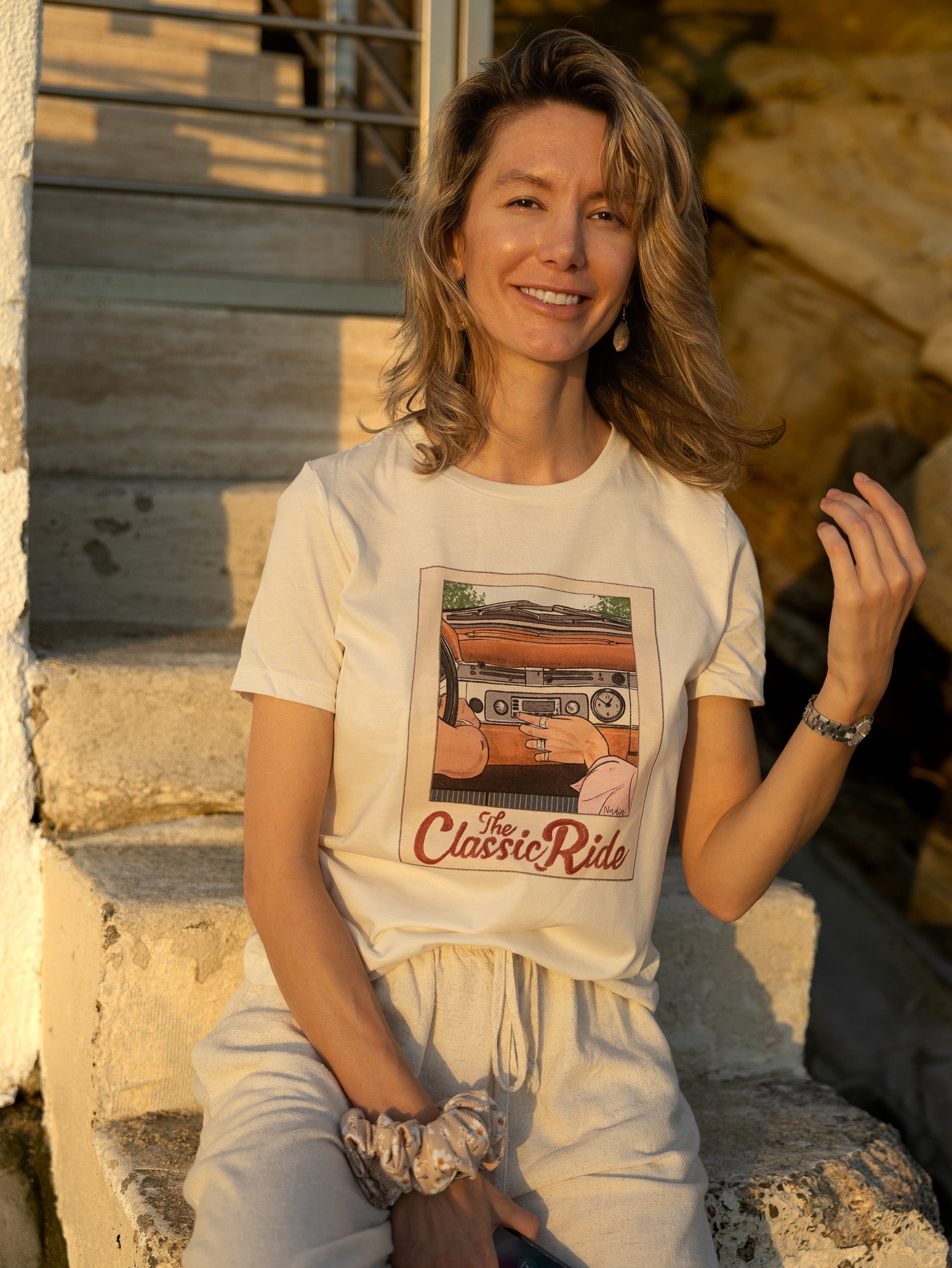 Close-up of a women's cream t-shirt featuring a hand-drawn vintage car dashboard and "The Classic Ride" text