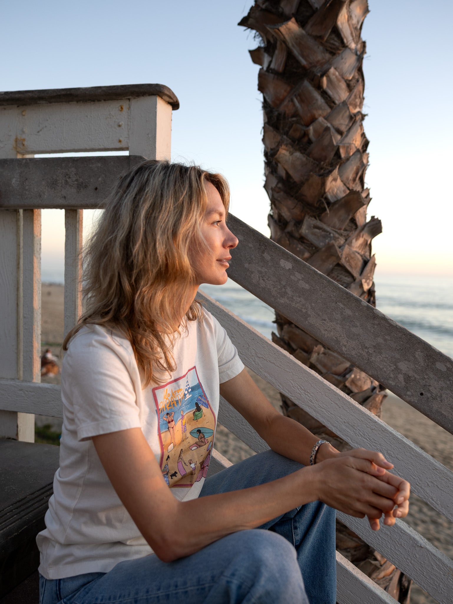 Women's soft cotton t-shirt with a hand-drawn "Hello from Paradise" tropical beach scene, North Shore Girls brand.