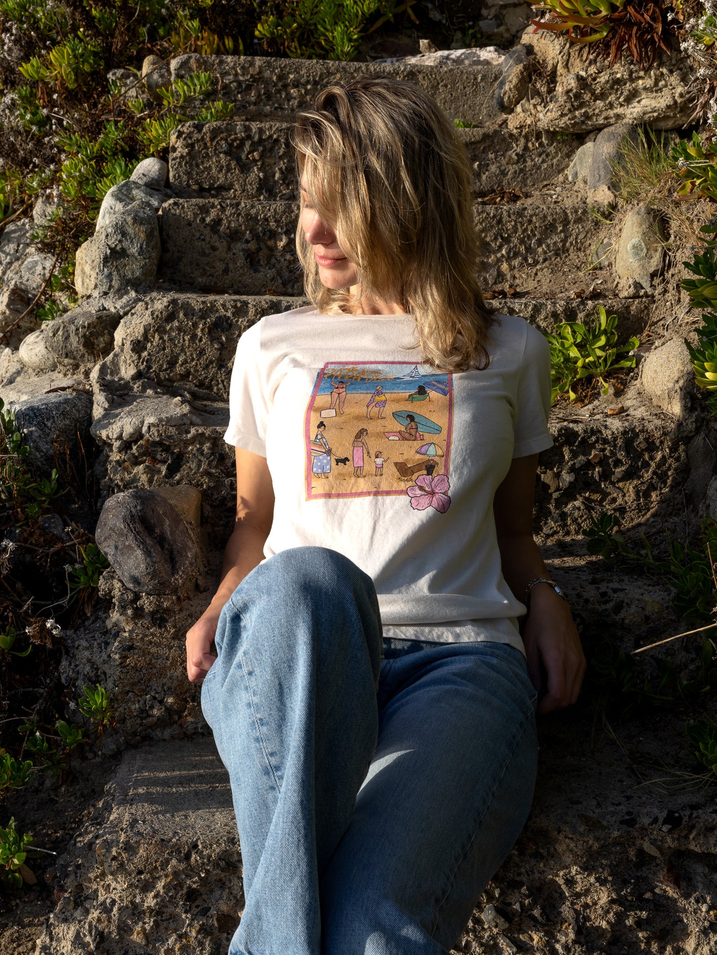 Women's soft cotton t-shirt with a hand-drawn "Hello from Paradise" tropical beach scene, North Shore Girls brand.