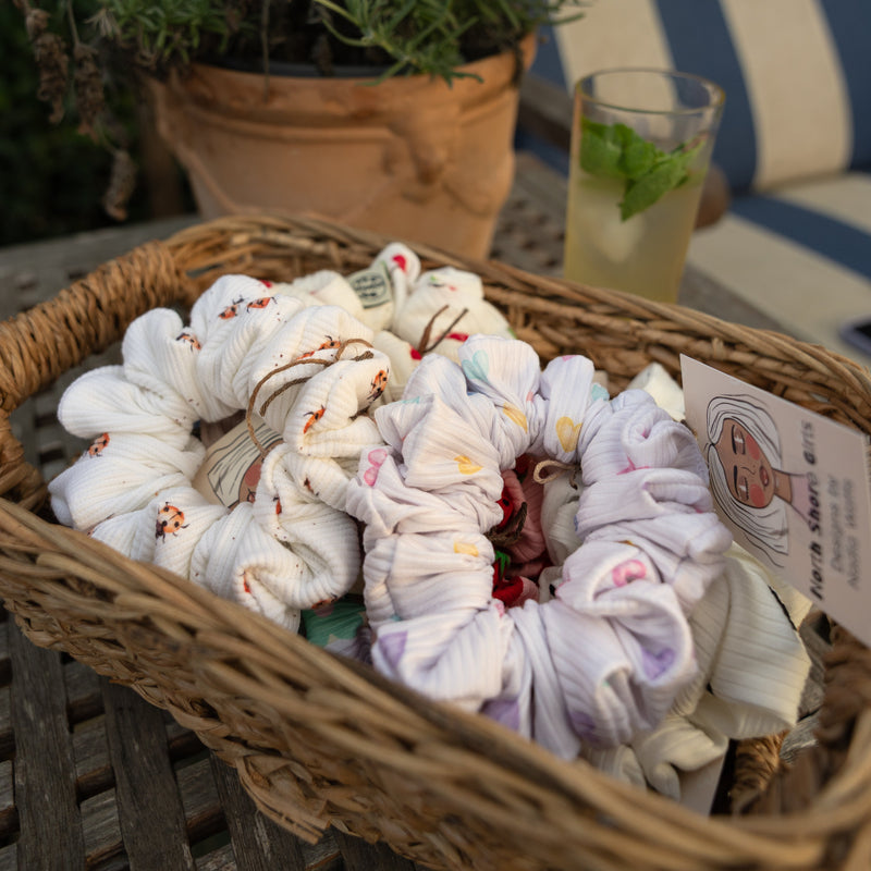 A woven basket of handmade scrunchies by North Shore Girls