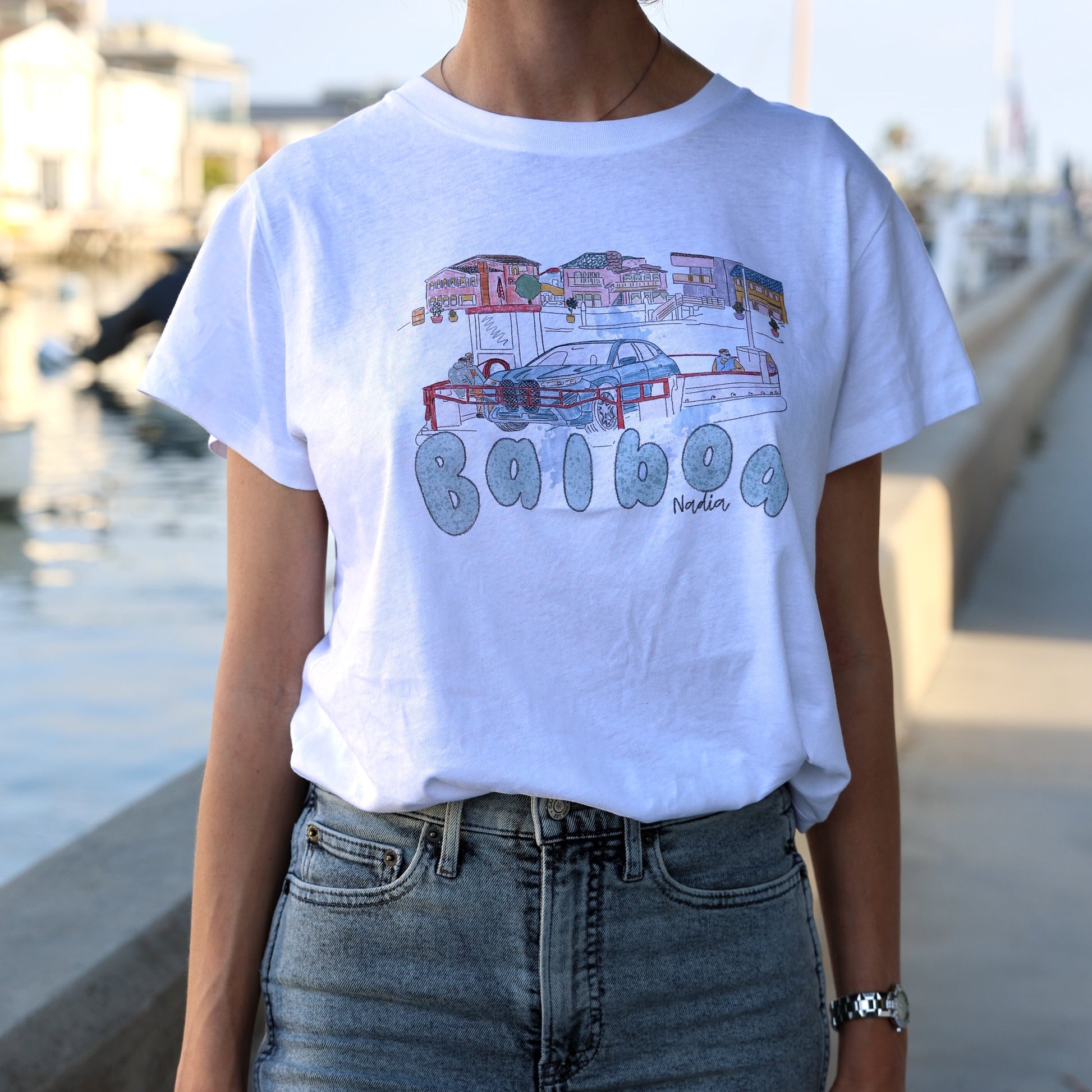 Woman is wearing Balboa Island Ferry graphic tee, illustrated by local artist.