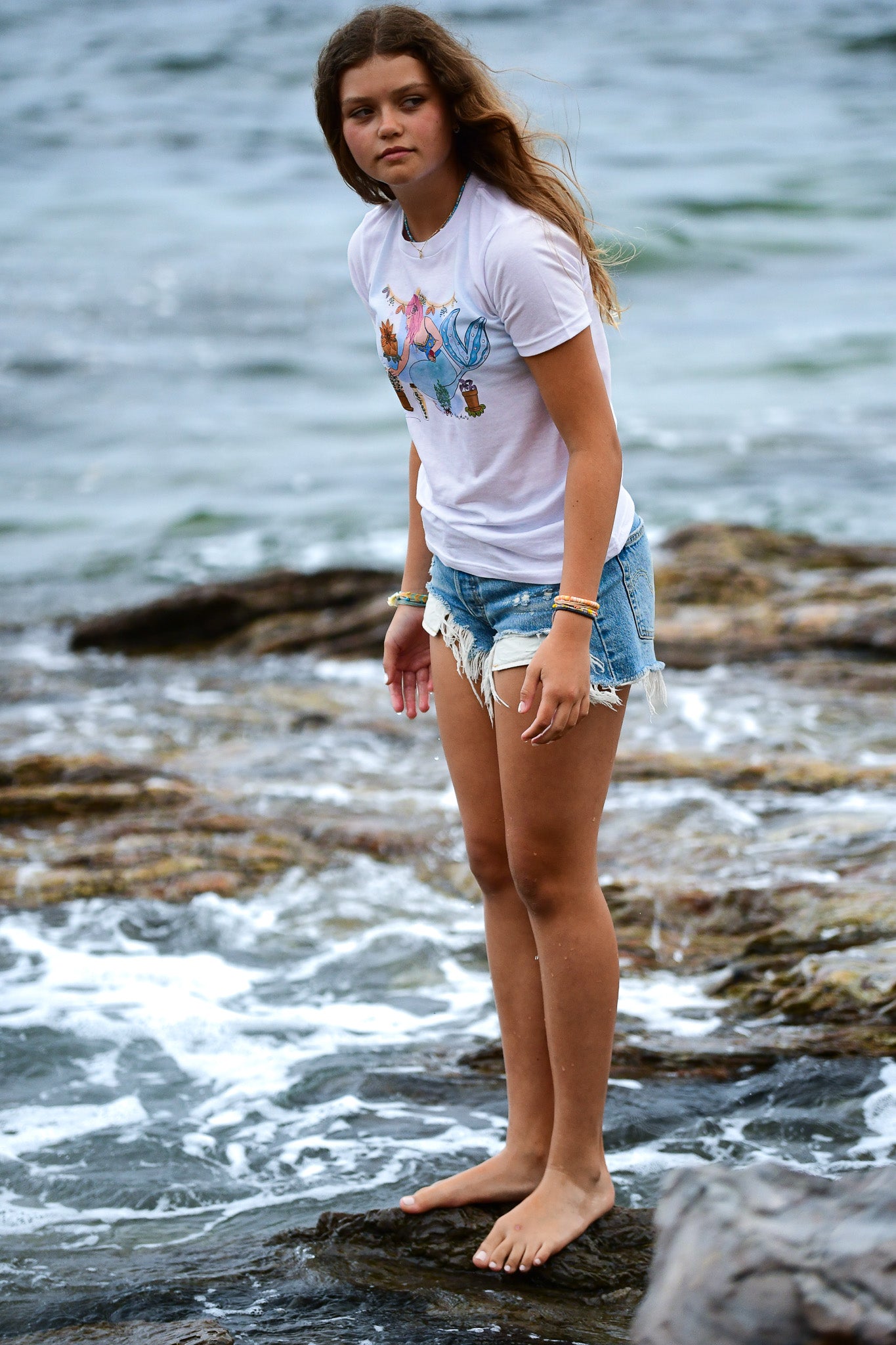 North Shore Girls graphic tee collection for girls. Pink hair mermaid planting flowers illustrated by an artist in Southern California. Beach surf tee