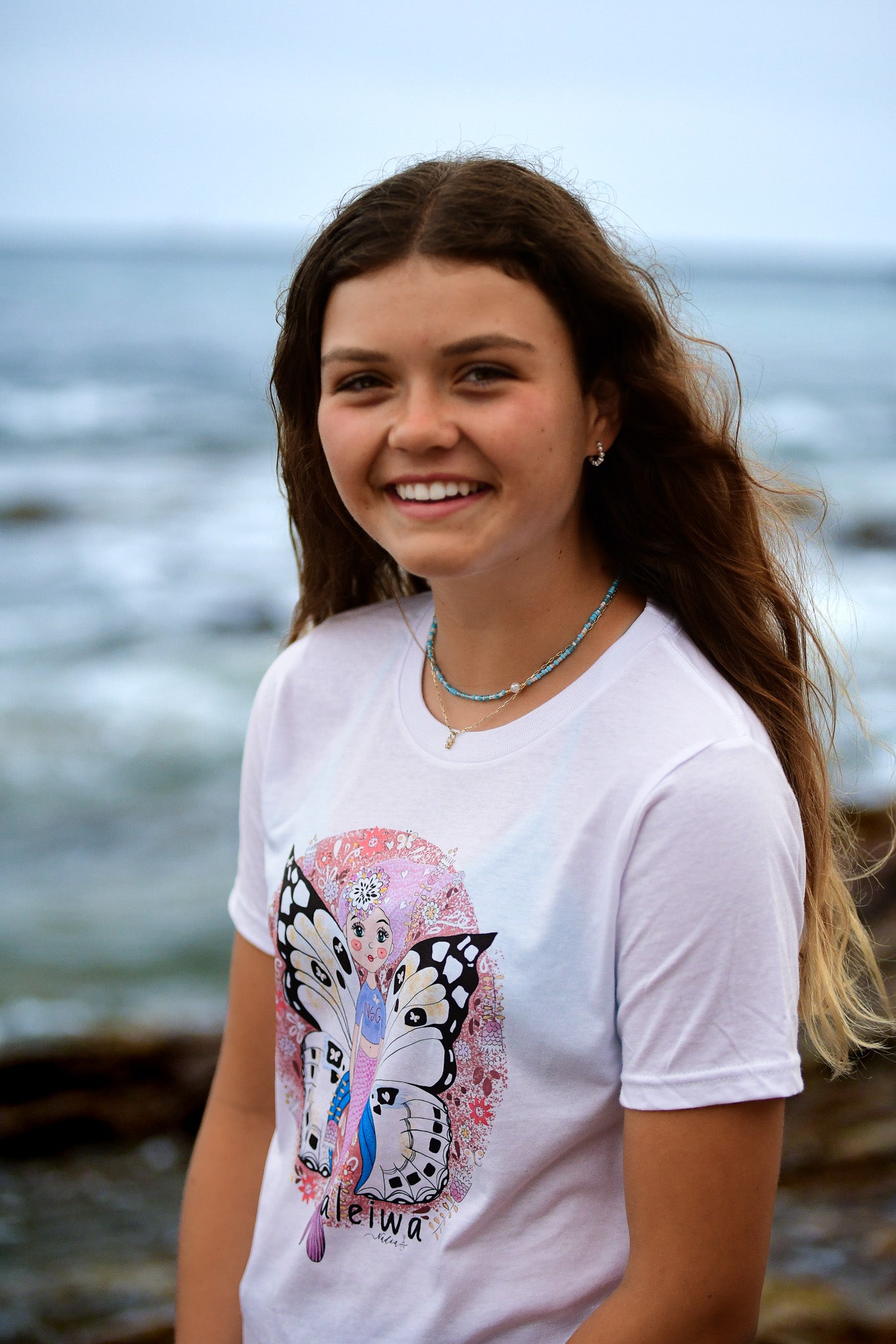 North Shore Girls Haleiwa inspired graphic tee featuring mermaid with butterfly wings and flowers. Art created by Nadia Watts
