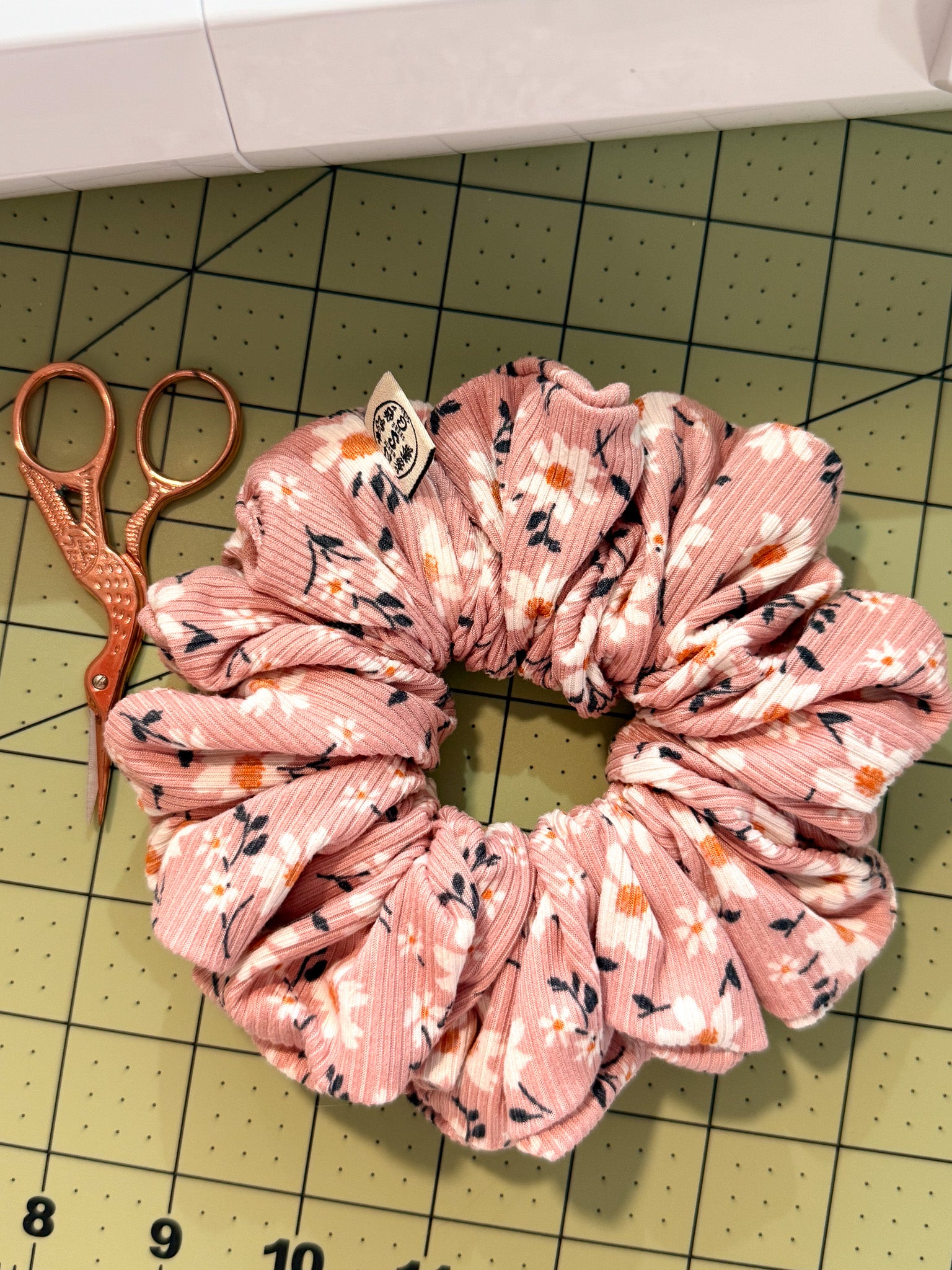Pink floral scrunchie on a cutting mat with scissors