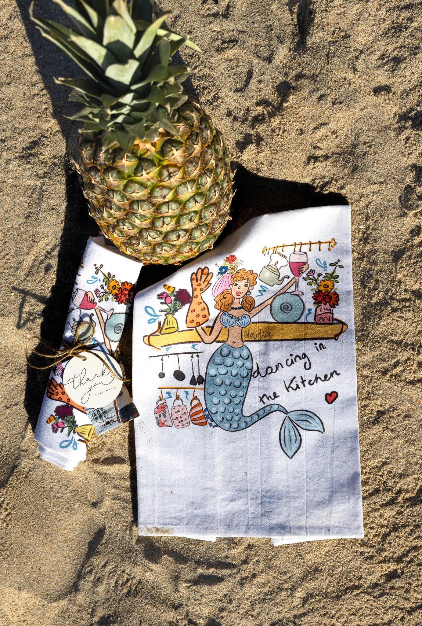 Hand‑illustrated mermaid holding a wine glass on a soft cotton kitchen towel – “Dancing in the Kitchen” design