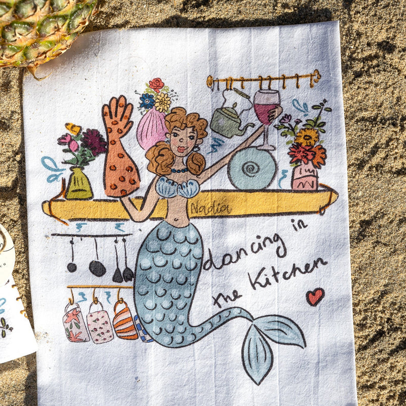 Hand‑illustrated mermaid holding a wine glass on a soft cotton kitchen towel – “Dancing in the Kitchen” design
