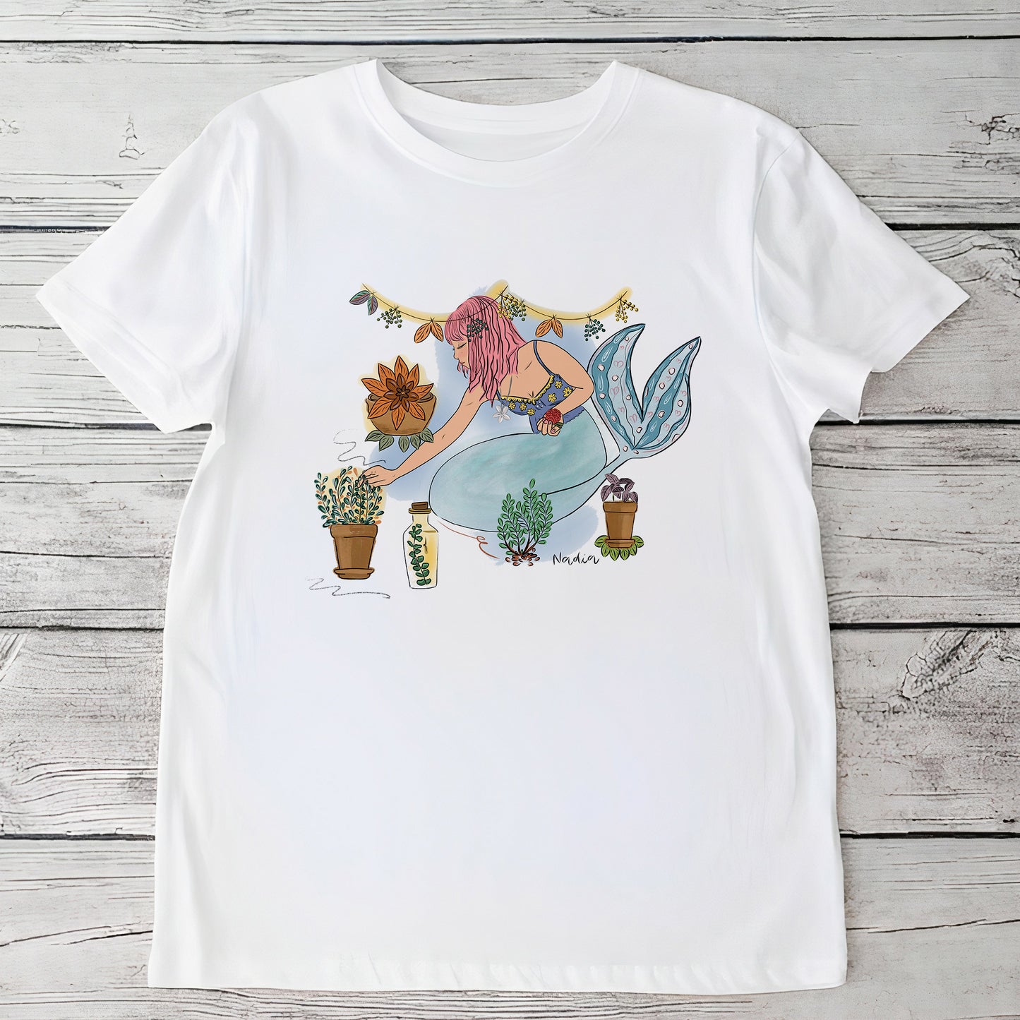 Youth white t-shirt with a hand-drawn mermaid tending to bohemian potted garden plants, North Shore Girls brand.