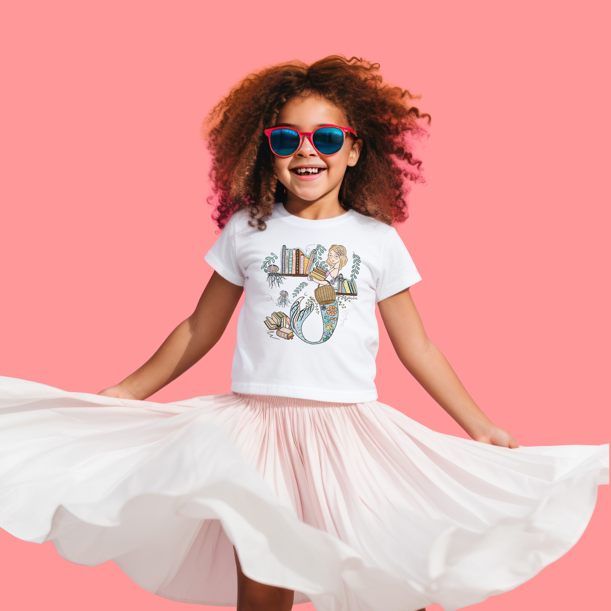 Illustrated toddler tee showing a mermaid with glasses next to a bookshelf, holding books – literary ocean theme