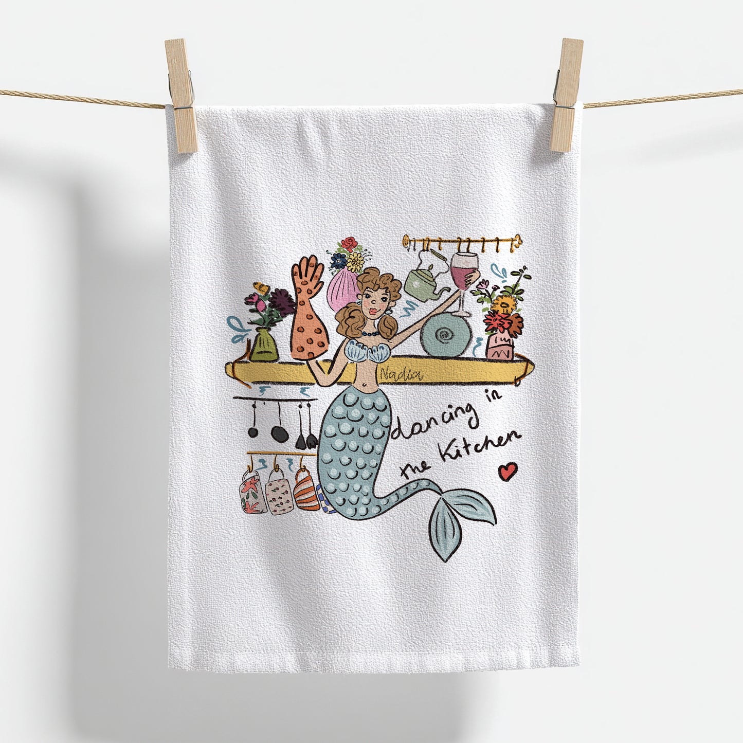 Shop North Shore Girls. This 18x28 inch premium thin cotton kitchen towel features a dancing mermaid illustration signed by Nadia Watts.