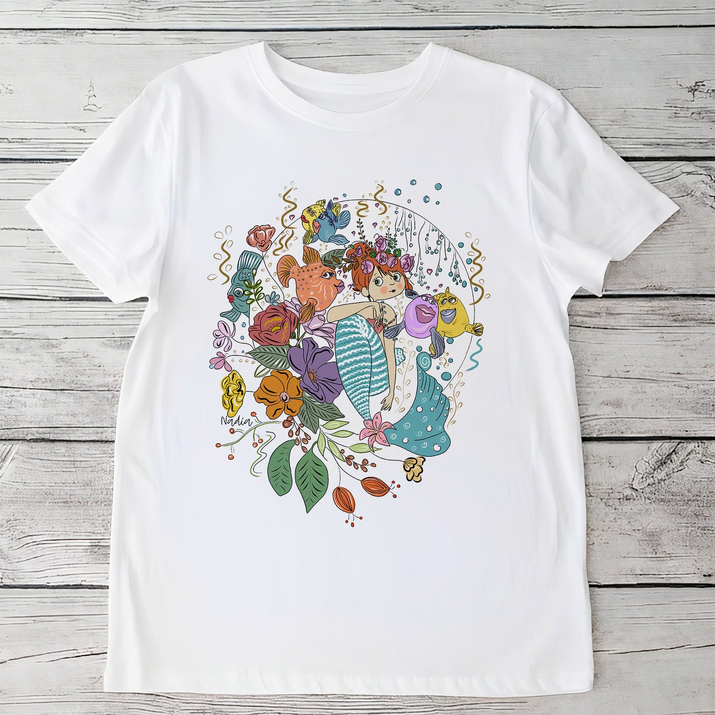 Youth white t-shirt with a hand-drawn mermaid, colorful fish, and flowers, North Shore Girls brand.
