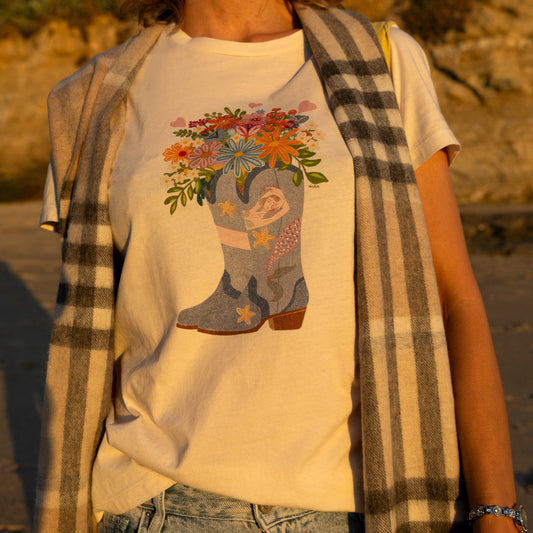 Women's white graphic t-shirt featuring a hand-drawn cowboy boot with a mermaid and flowers, North Shore Girls brand.