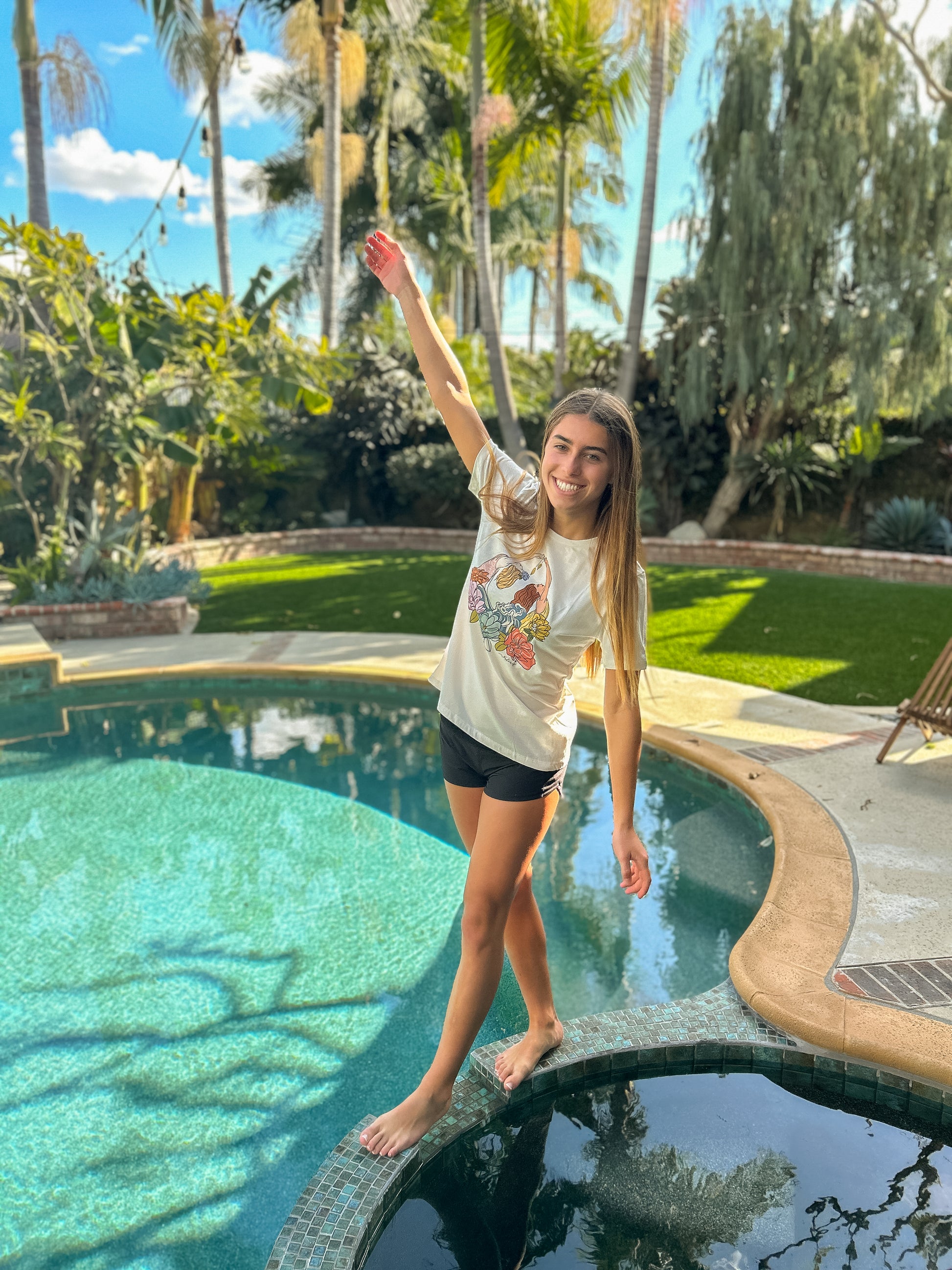 Girl standing by a swimming pool wearing North Shore Girls  graphic tee